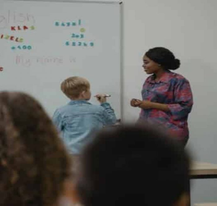 Kid studing English grammar on a blackboard