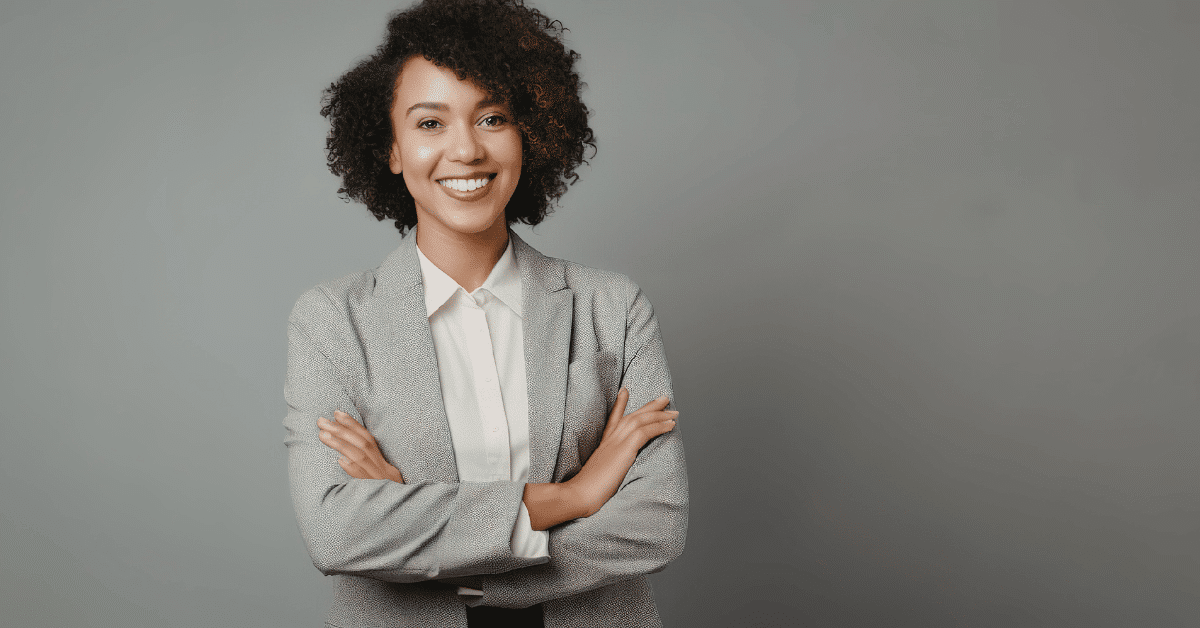 A female professional smiling at the camera confidently. Develop your Business English skills with Oxford International and improve your career outcomes.