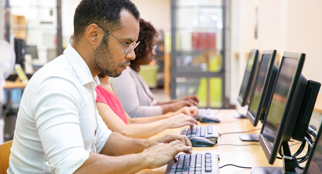 Male student on computer taking the IELTS exam. Prepare for the IELTS with Oxford International in the UK, Canada, USA or Australia.
